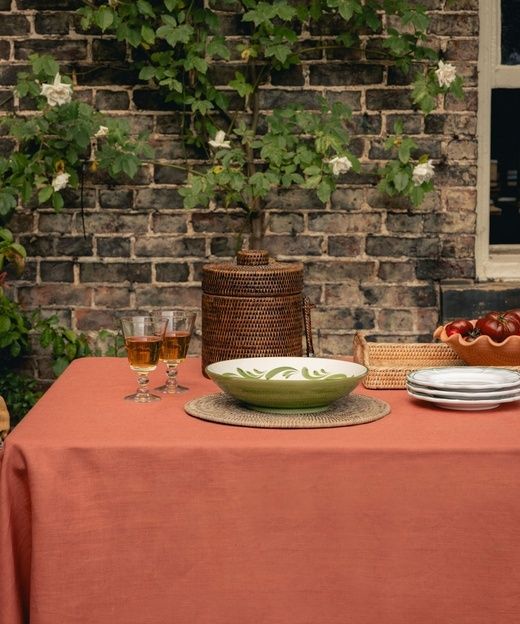 Gedekte tafel met linnen kleed, keramieken schaal en wijnglazen